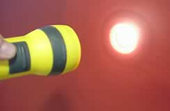 A torch shining a beam of light onto a wall.